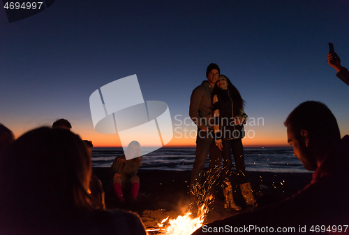 Image of Friends having fun at beach on autumn day