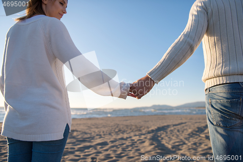 Image of Loving young couple on a beach at autumn sunny day