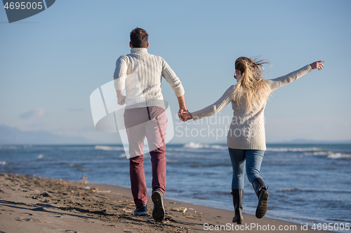 Image of Loving young couple on a beach at autumn sunny day