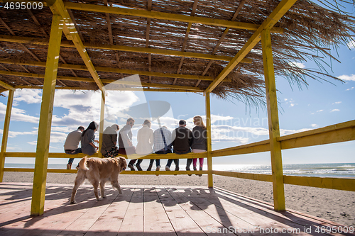 Image of Group of friends having fun on autumn day at beach