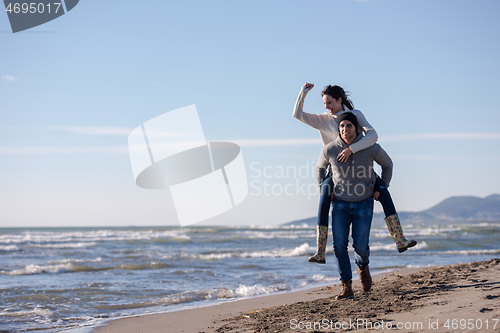 Image of couple having fun at beach during autumn