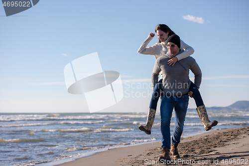 Image of couple having fun at beach during autumn