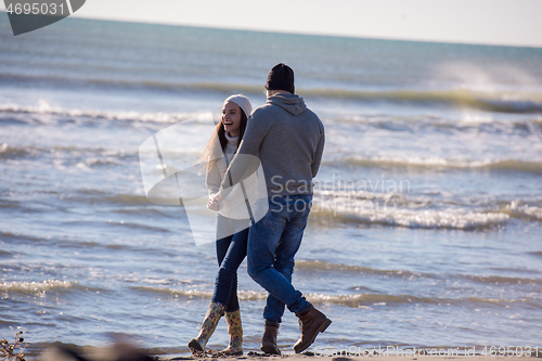 Image of Loving young couple on a beach at autumn sunny day