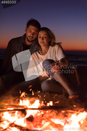 Image of portrait of young Couple enjoying  at night on the beach