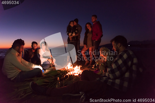 Image of Friends having fun at beach on autumn day