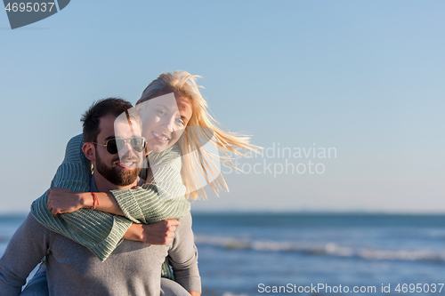 Image of couple having fun at beach during autumn