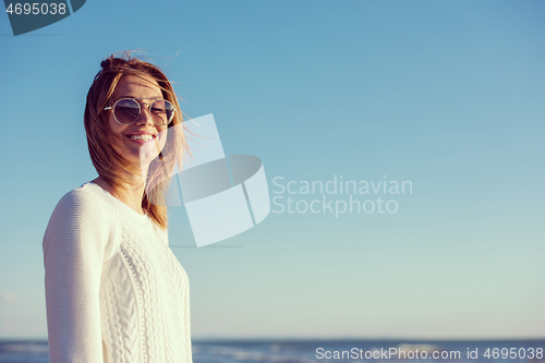 Image of Young woman enjoying the warm autumn day