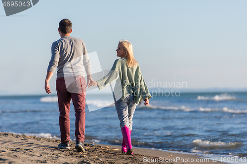 Image of Loving young couple on a beach at autumn sunny day