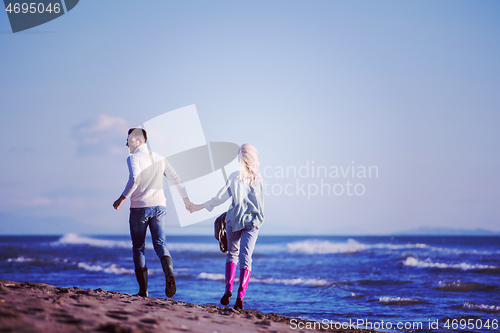 Image of Loving young couple on a beach at autumn sunny day