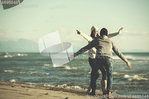 Image of Loving young couple on a beach at autumn sunny day