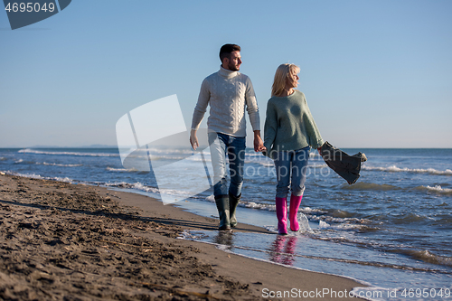 Image of Loving young couple on a beach at autumn sunny day