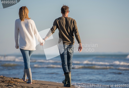 Image of Loving young couple on a beach at autumn sunny day