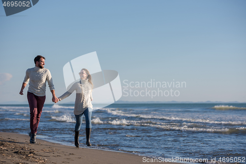 Image of Loving young couple on a beach at autumn sunny day