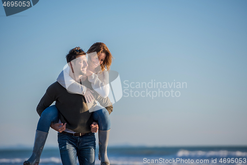 Image of couple having fun at beach during autumn