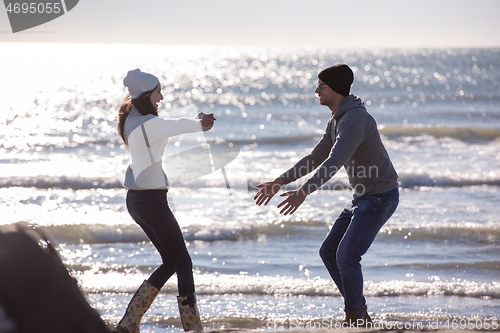 Image of Loving young couple on a beach at autumn sunny day