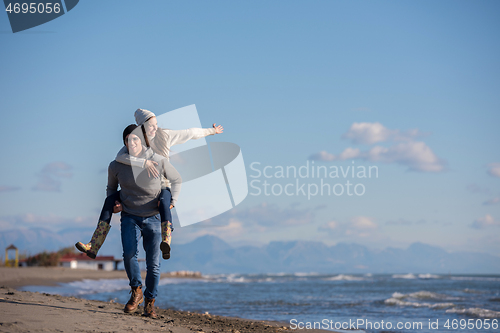 Image of couple having fun at beach during autumn