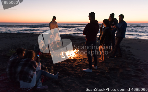 Image of Friends having fun at beach on autumn day