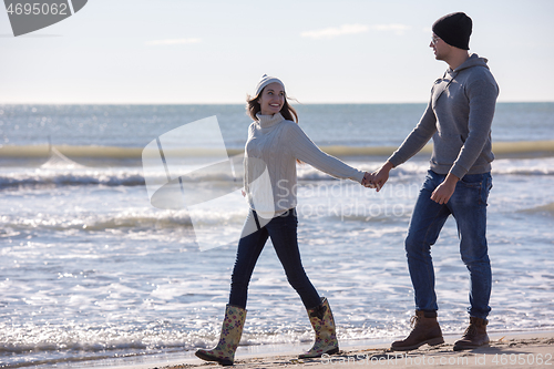 Image of Loving young couple on a beach at autumn sunny day