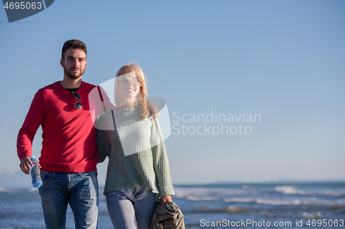 Image of Loving young couple on a beach at autumn sunny day