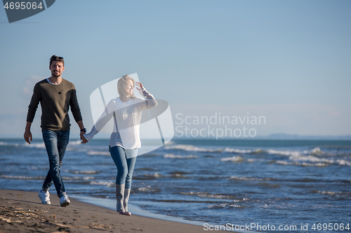 Image of Loving young couple on a beach at autumn sunny day