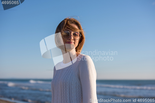 Image of Young woman enjoying the warm autumn day