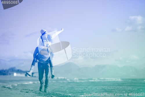 Image of couple having fun at beach during autumn