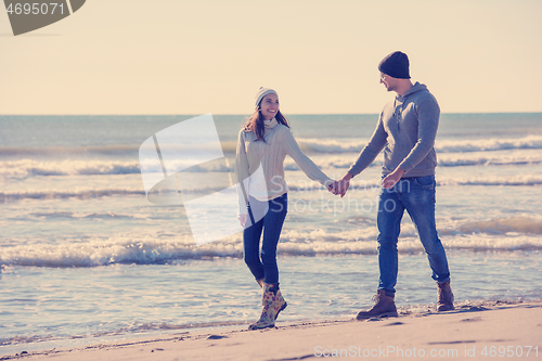 Image of Loving young couple on a beach at autumn sunny day