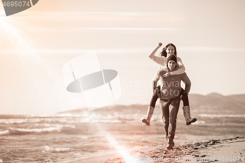 Image of couple having fun at beach during autumn