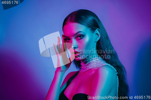 Image of High Fashion model in colorful bright neon lights posing at studio