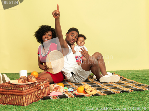 Image of Happy family having picnic at studio