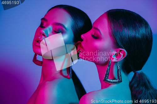 Image of High Fashion models in colorful bright neon lights posing at studio