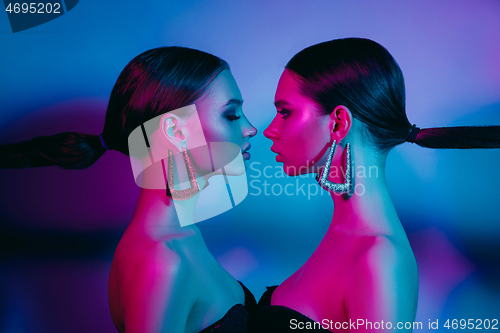 Image of High Fashion models in colorful bright neon lights posing at studio