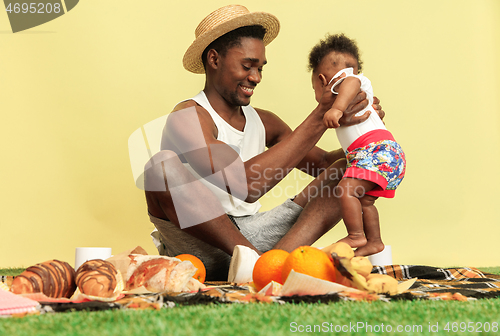 Image of Happy family having picnic at studio