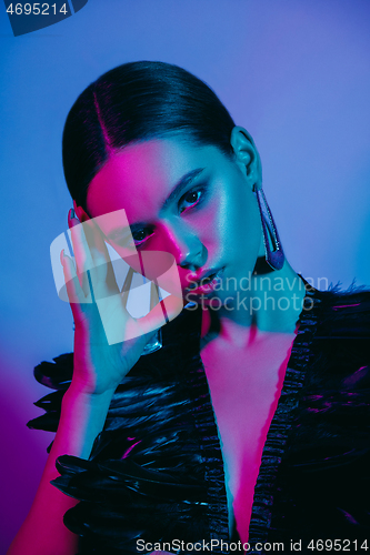 Image of High Fashion model in colorful bright neon lights posing at studio