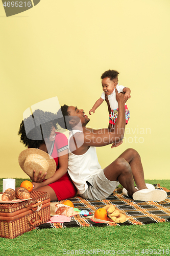 Image of Happy family having picnic at studio