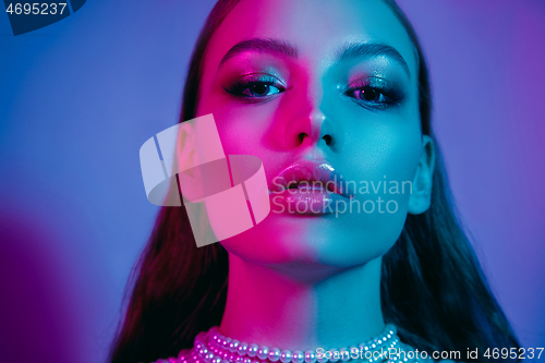 Image of High Fashion model in colorful bright neon lights posing at studio