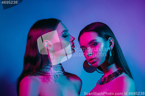 Image of High Fashion models in colorful bright neon lights posing at studio