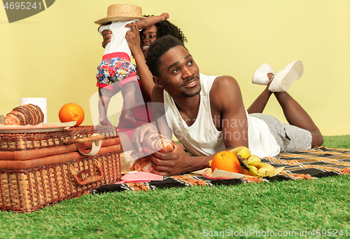 Image of Happy family having picnic at studio