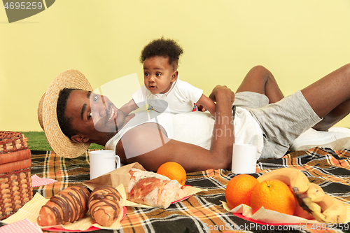 Image of Happy family having picnic at studio