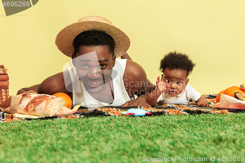 Image of Happy family having picnic at studio