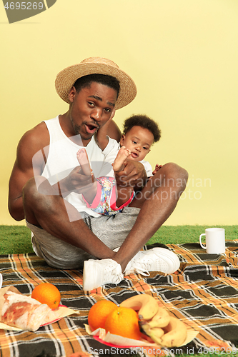 Image of Happy family having picnic at studio