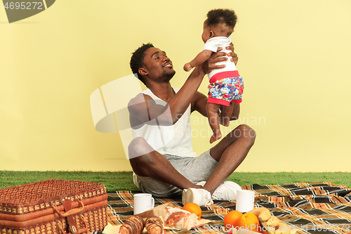 Image of Happy family having picnic at studio