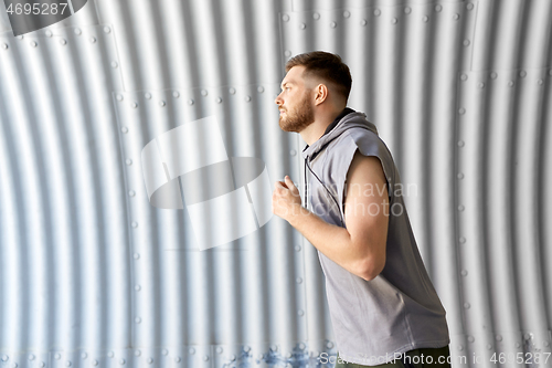 Image of sporty young man running in tunnel