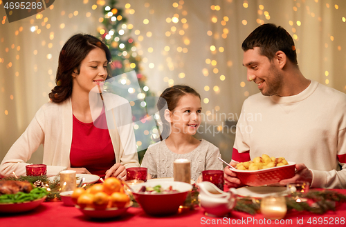 Image of happy family having christmas dinner at home