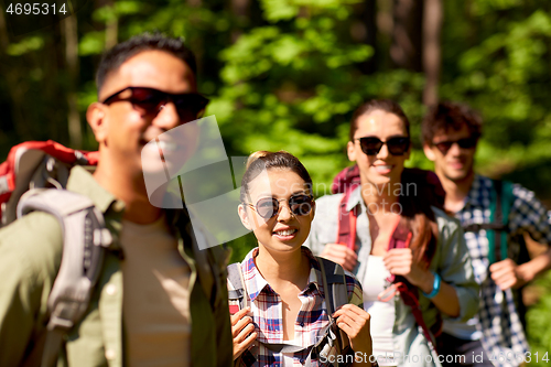 Image of group of friends with backpacks hiking in forest