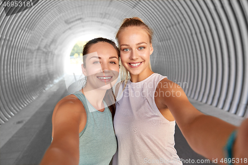 Image of sporty women or friends taking selfie in tunnel