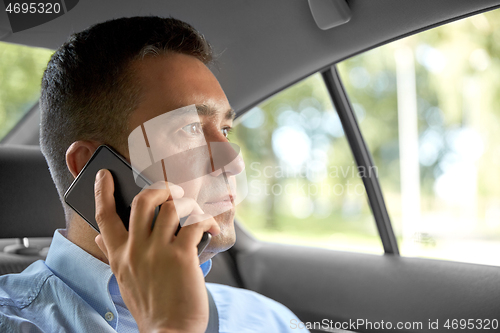 Image of male passenger calling on smartphone in taxi car