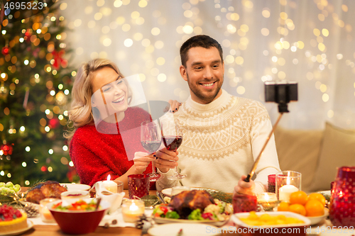 Image of happy couple taking selfie at christmas dinner