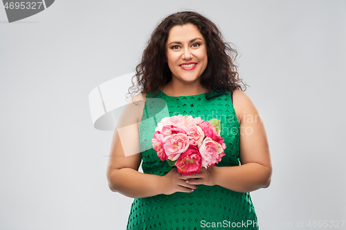 Image of happy woman in green dress with flower bunch