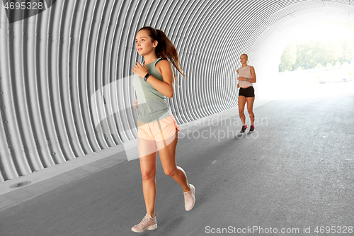 Image of young women or female friends running outdoors